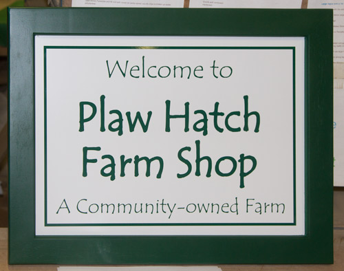 Wooden framed sign painted heritage green on white aluminium compopsite with dark green letters