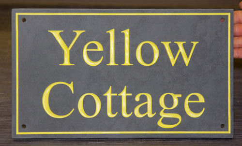 Slate sign with yellow text and line border