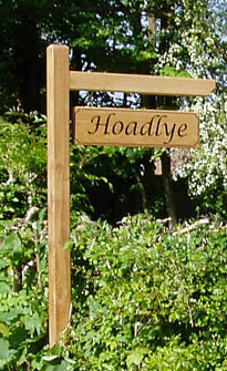 Wooden sign on post with arm