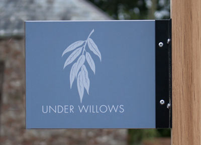 A projecting sign using t-channel on an oak posts.