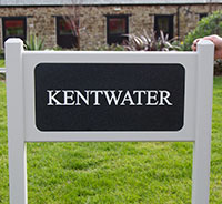 Engraved corian plaque inset into painted wooden sign. Engraved corian plaque inset into painted wooden sign.