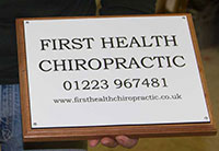 White engraved plaque with black text - on a backing board.