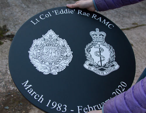 Detailed images on round slate sign.