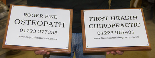 White engraved plaques on sapele wood backing boards
