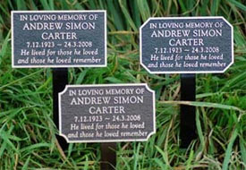 Cast bronze memorials on tree stakes.