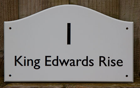 Engraved house sign in an arch top shape made in white corian.