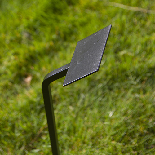 Wrought iron tree stake with flat plate for use with double sided tape.