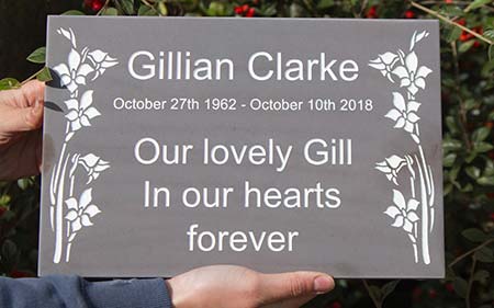 Slate memorial with engraved images.