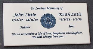 White engraved memorial plaque with blue text.