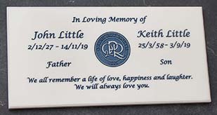 White engraved memorial plaque with blue text. White engraved memorial plaque with blue text.
