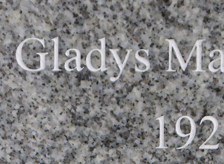 Close up of white lettering on celtic grey granite mememorial.