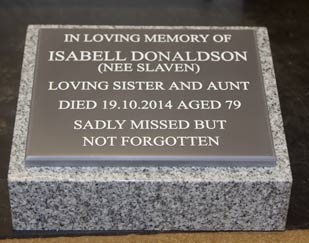 Engraved corian plaque on granite plinth. Engraved corian plaque on granite plinth.