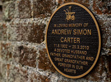 Round bronze plaque with a brouwn background.