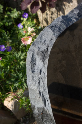 Side of granite boulder showing polished black face