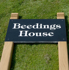 Black granite sign inset into two oak posts.