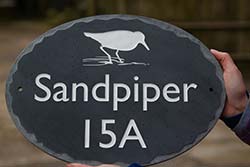 Oval slate house sign with random edge border. Oval slate house sign with random edge border.