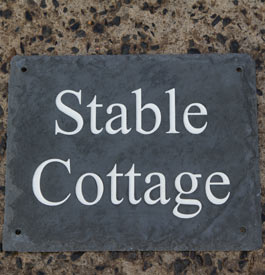 Rustic slate house sign with white text