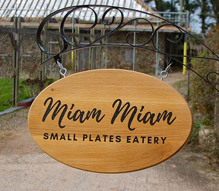 Oval wooden sign on a Parisian Arch Bracket