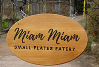 Hanging oval wood sign on a bracket. Hanging oval wood sign on a bracket.