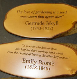 Rustic wooden sign with sayings engraved into the wood.