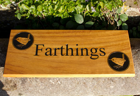 A beautiful Iroko wood house sign with the farthing image on it. 